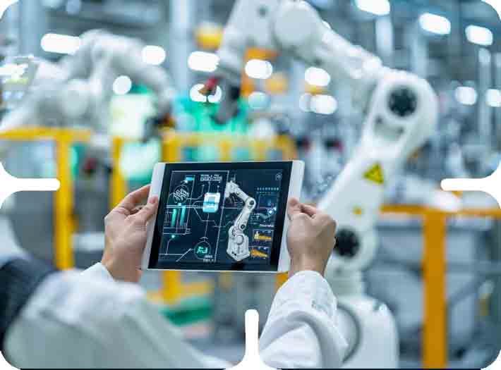 Engineer using a digital tablet to monitor robotic arms and smart factory solutions on an automated assembly line.